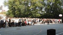 a large group of people are gathered in a basketball court