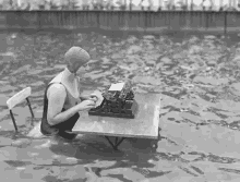 a woman is typing on a typewriter in a swimming pool