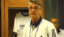 a man wearing glasses is standing in front of a locker with a shirt that says france on it .