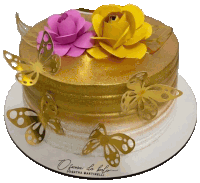 a gold and white cake with butterflies and flowers on top