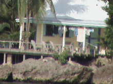 a house sits on stilts overlooking a river