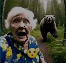 an elderly woman with a surprised look on her face stands next to a bear in the woods