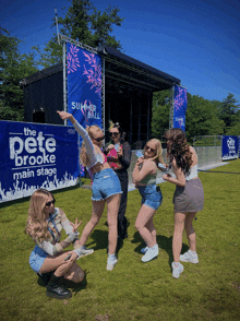 a group of young women are posing for a picture in front of a banner that says the pete brooke main stage