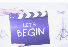 a person is holding a movie clapper board that says let 's begin .