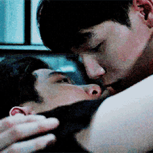 a man is kissing another man on the neck in a blurry photo