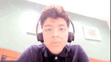 a young boy wearing headphones and glasses is on a video call with a name that starts with t.