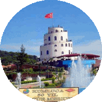 a fountain in front of a tower that says kumluca 50 yıl