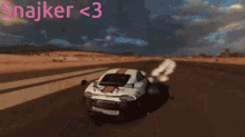 a car is driving down a road with the words " snajker < 3 " written above it