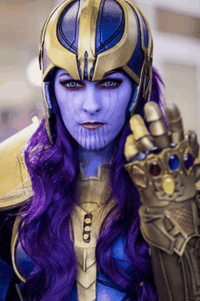 a woman in a thanos costume has purple hair and blue eyes