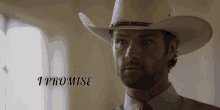 a man wearing a cowboy hat with the words i promise behind him