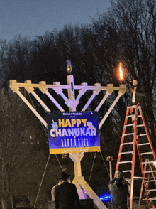 a sign that says happy chanukah is on a menorah