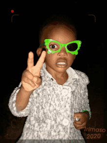 a little girl wearing green glasses giving a peace sign and the year 2020