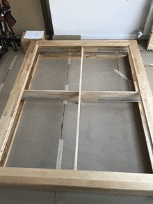 a wooden frame is sitting on a cardboard surface