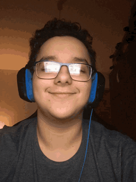 a man wearing glasses and headphones smiles for the camera