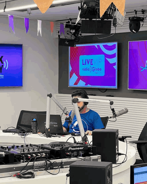 a man in a blue shirt stands in front of a pioneer mixer