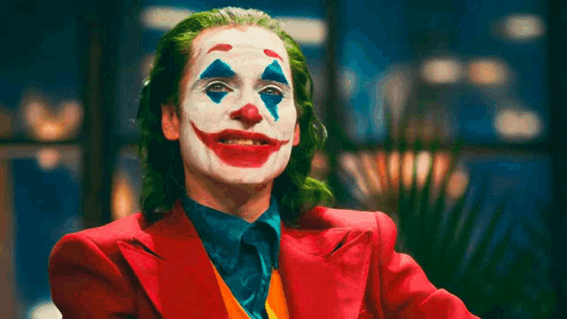 a close up of a person dressed as the joker in a red suit