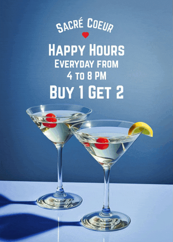 two martini glasses on a table with a sign that says happy hours everyday from 4 to 8pm