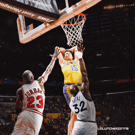 a basketball player wearing a number 23 jersey goes up for a dunk