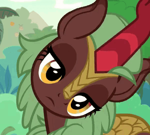 a close up of a cartoon pony with green hair and a red horn