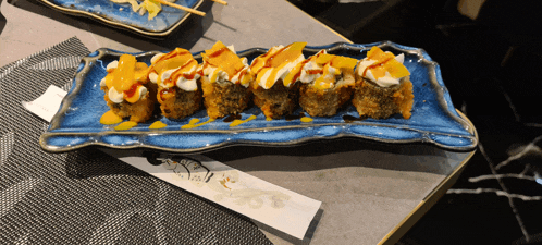 a plate of food with chopsticks and a paper that says sushi on it