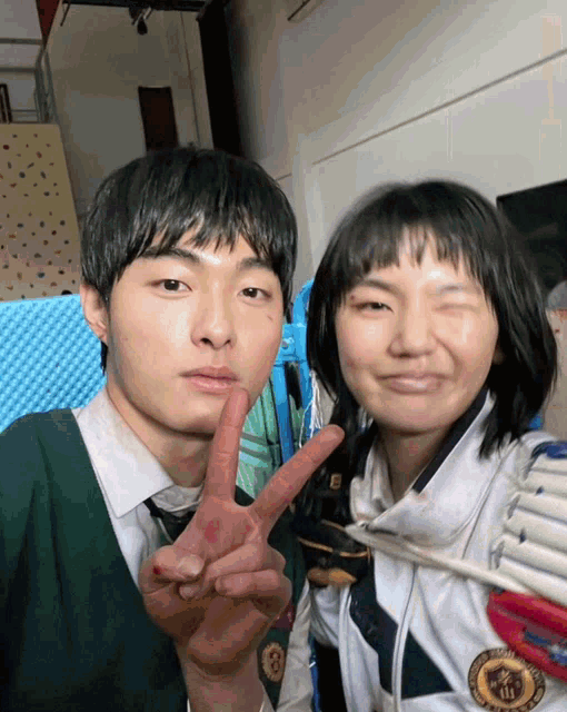 a boy and a girl are posing for a picture and the girl is wearing a medal that says seoul university