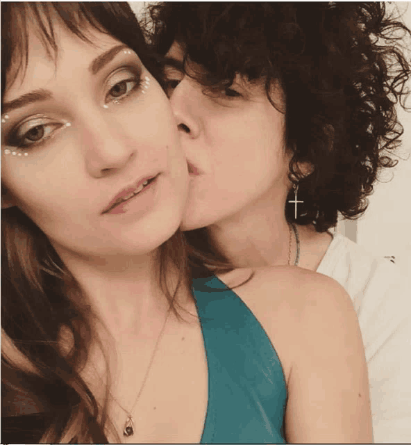 a woman kissing another woman on the cheek