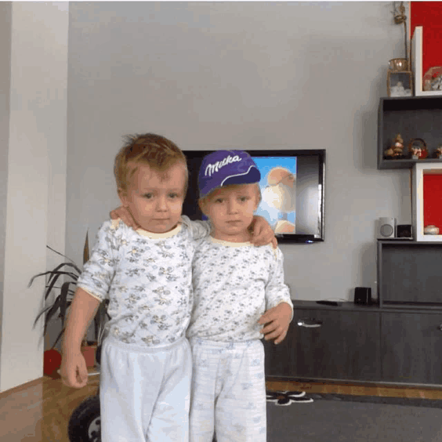 a boy wearing a milka hat stands with another boy