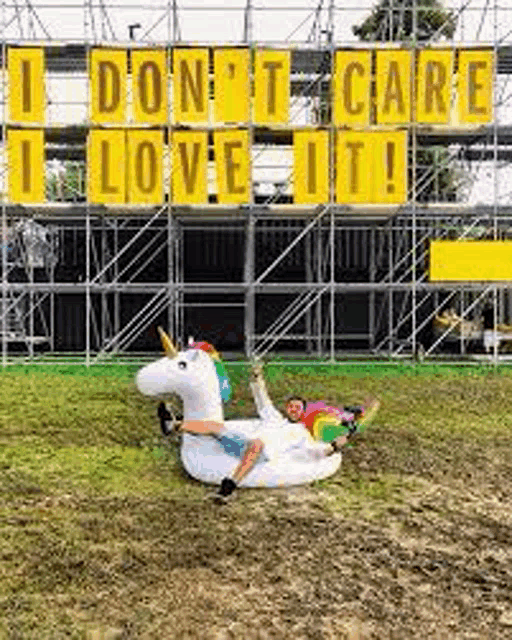 a man is laying on top of a giant inflatable unicorn .