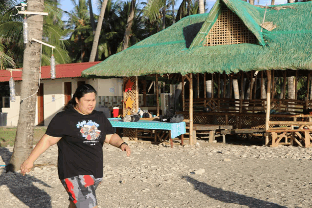 a woman wearing a black shirt that says ' hawaiian ' on it