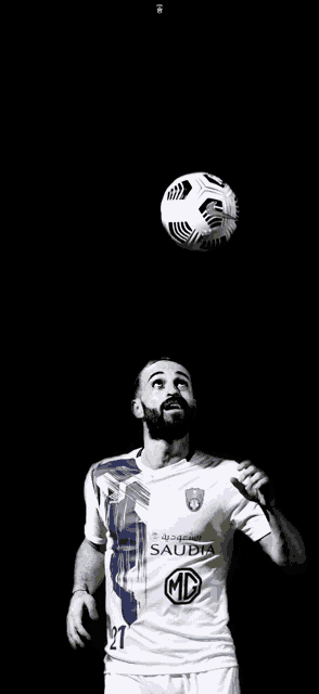 a soccer player with a beard is holding a soccer ball in his hand .