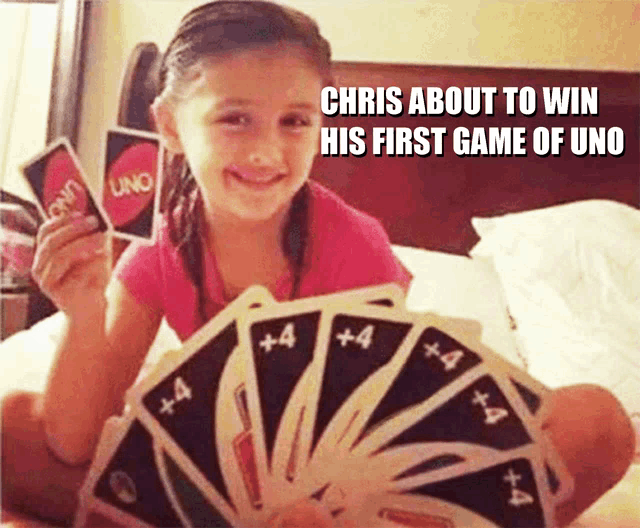 a young girl is holding a fan of uno cards