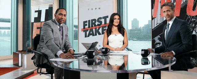 three people sit at a table in front of a sign that says " first take "