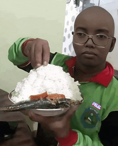 a boy wearing glasses is holding a plate of food that says f2s on it