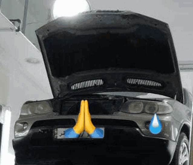 a car with its hood open and praying hands on the front .