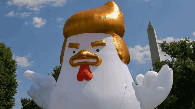 a large inflatable chicken with a gold hat and a red beak