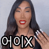 a woman with long hair and red lips is smiling and holding her hand up with the word choix on it .