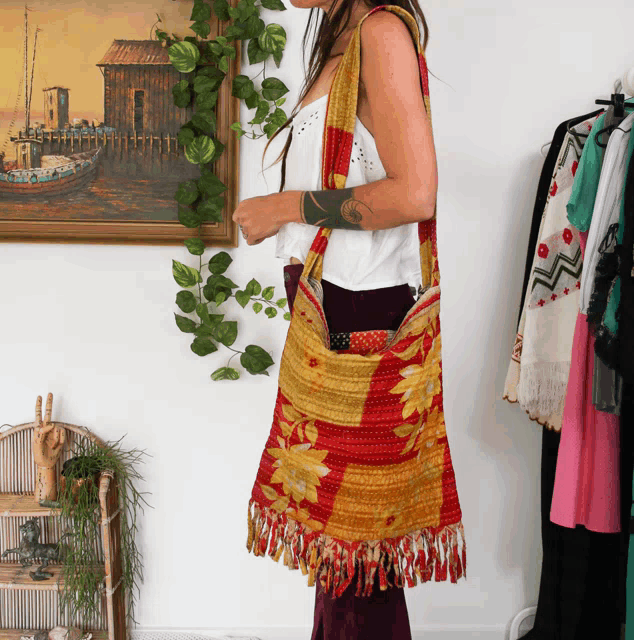 a woman with a tattoo on her arm is standing in front of a painting