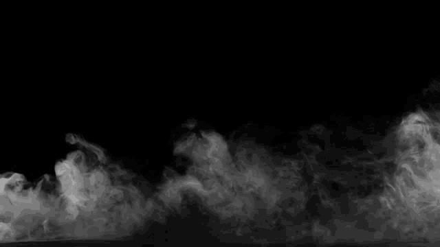 there is a lot of smoke coming out of the bottom of the image on a black background .