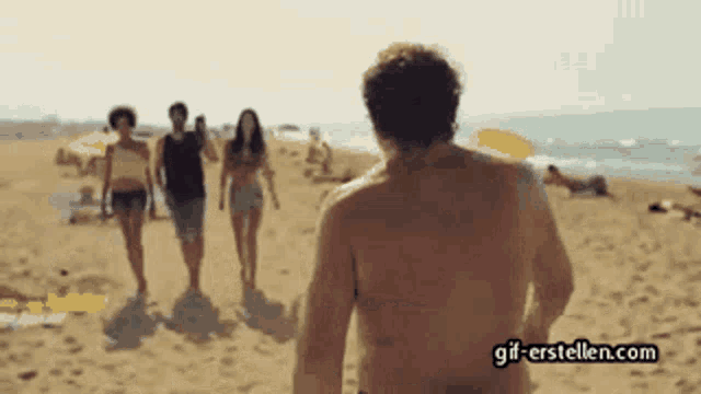 a group of people walking on a beach with the website gif-erstellen.com in the lower right corner