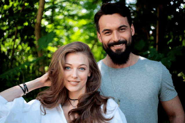 a man with a beard and a woman with long hair are standing next to each other