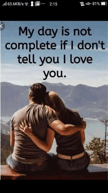 a man and a woman are hugging each other while sitting on a bench with mountains in the background