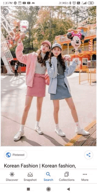 two girls are standing next to each other in front of a ferris wheel .