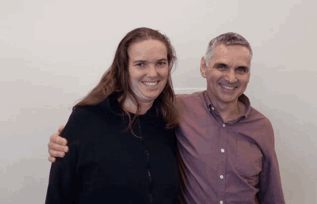 a man and a woman are posing for a picture and smiling