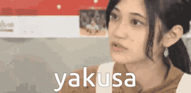 a close up of a woman 's face with the word yakusa behind her