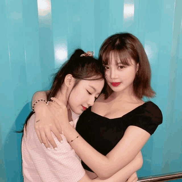 two girls hugging each other with one wearing a bracelet that says ' i love you '