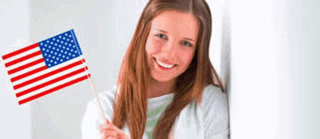 a young woman is holding an american flag in her hand .