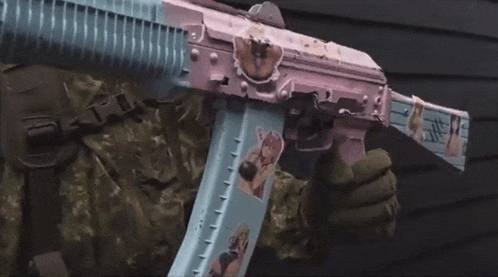 a person is holding a pink and blue assault rifle with stickers on it .