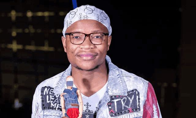 a man wearing a bandana and glasses is holding a doll that says try on it