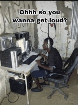 a man wearing headphones is sitting at a desk with a computer and a microphone .