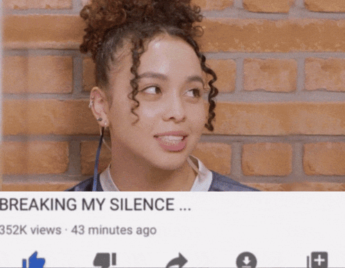 a woman with curly hair is standing in front of a brick wall with a video titled breaking my silence